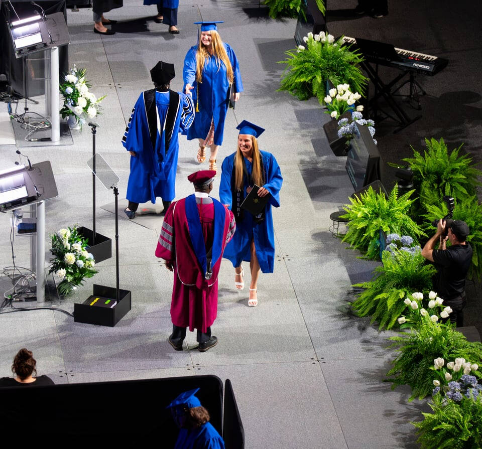 PCE students cross the commencement state to get their degree and to shake hands with Dean Bayo Ogundipe